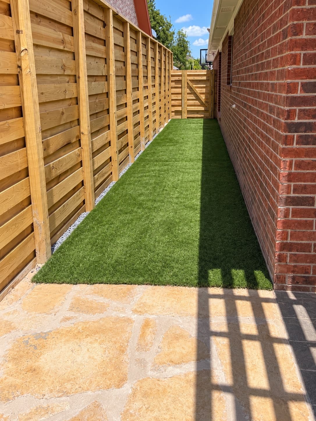 Side yard with artificial turf, flagstone and a new horizontal cedar fence