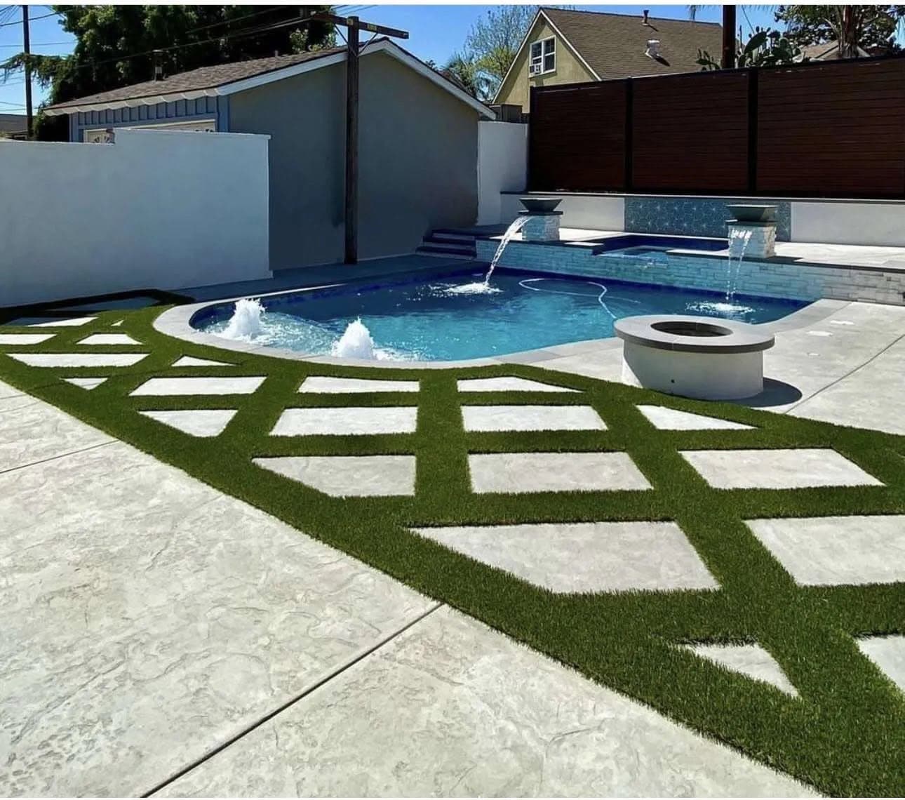 Finished residential pool with fire bowls and a turf-and-paver patio built by Southern Gardens in the Rio Grande Valley