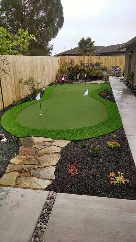 Custom backyard putting green with flagstone path and planting beds