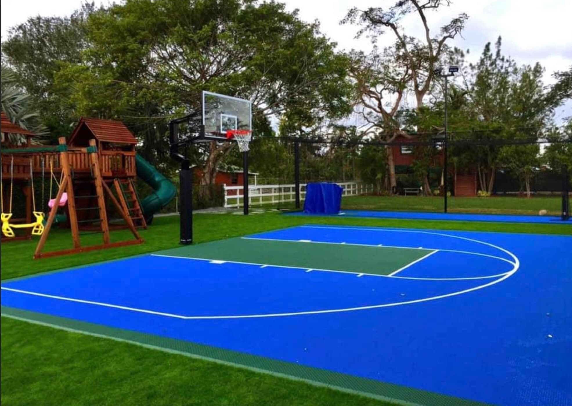 Blue-and-green backyard sport court wrapped in artificial turf